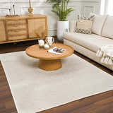 Living room scene with a Fadey White 3D Washable Rug, wood furniture, sofa, and plants for a bright, modern farmhouse look. Roomscene-Rectangle