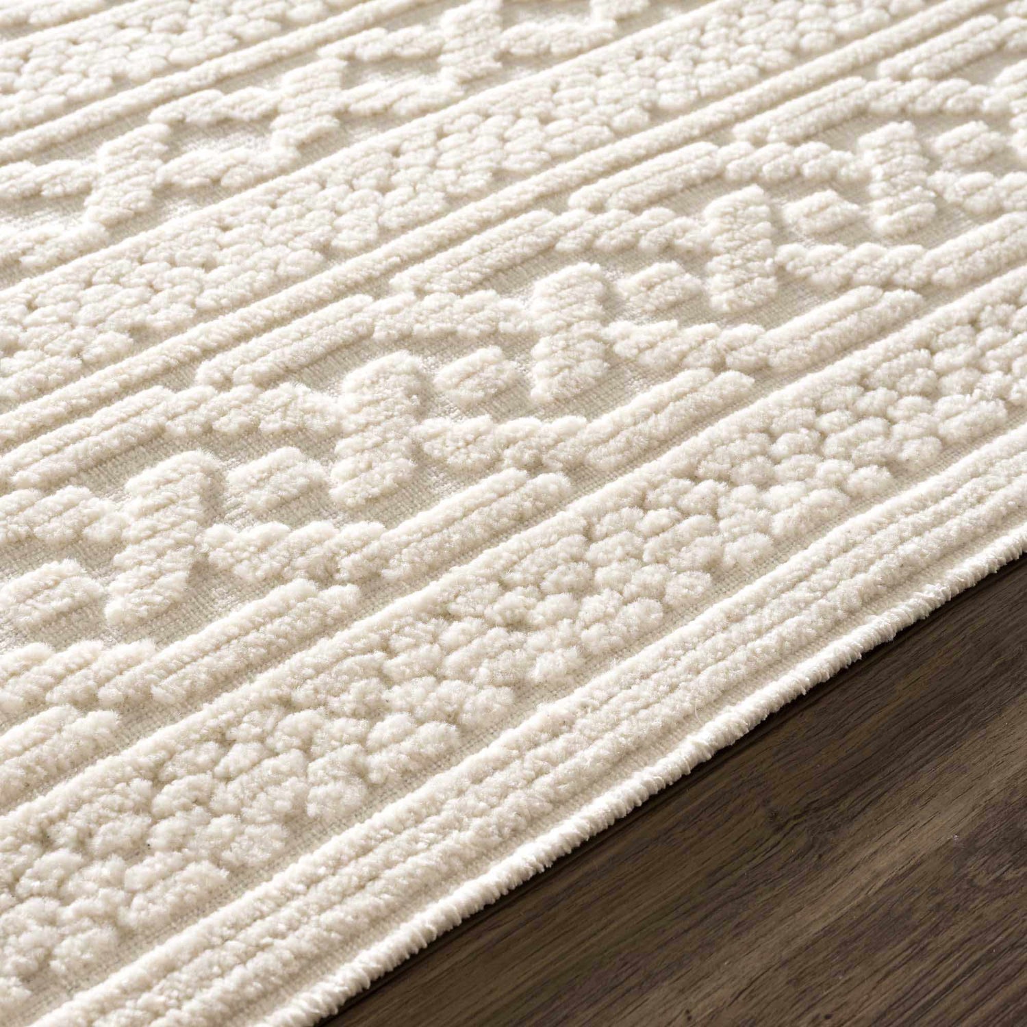 Close-up of the Fadey White 3D Washable Rug showing its geometric pattern and textured, off-white pile. Pile