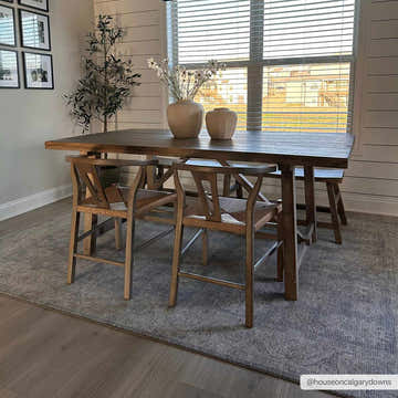 Dining room scene with a Coby Brown Avant Garde rug under a wood table and chairs near a window. Roomscene-Rectangle