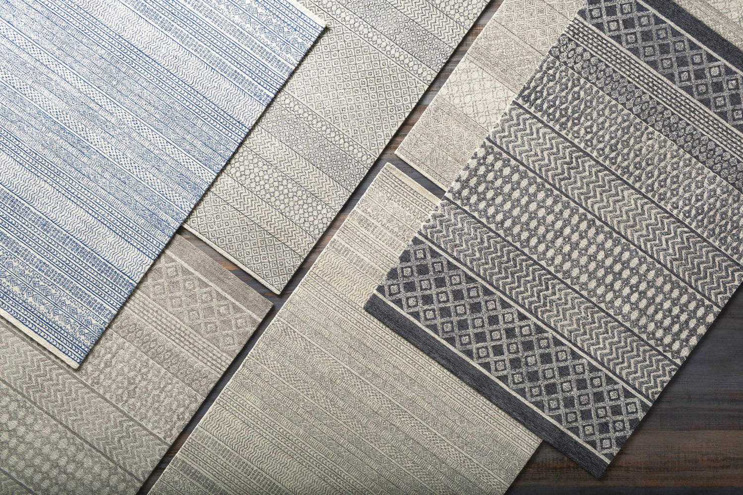 Close-up of assorted rugs, including the Lone Beige Tufted Maroc Wool Rug, showing geometric patterns and textures. Styleshot