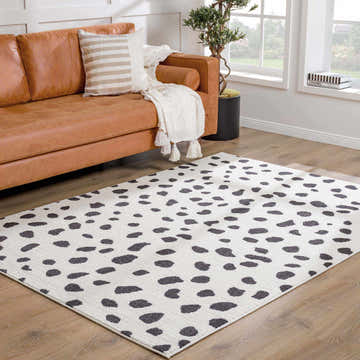 Living room scene with a brown leather sofa and the Tariffville Dalmatian Rug. Roomscene-Rectangle