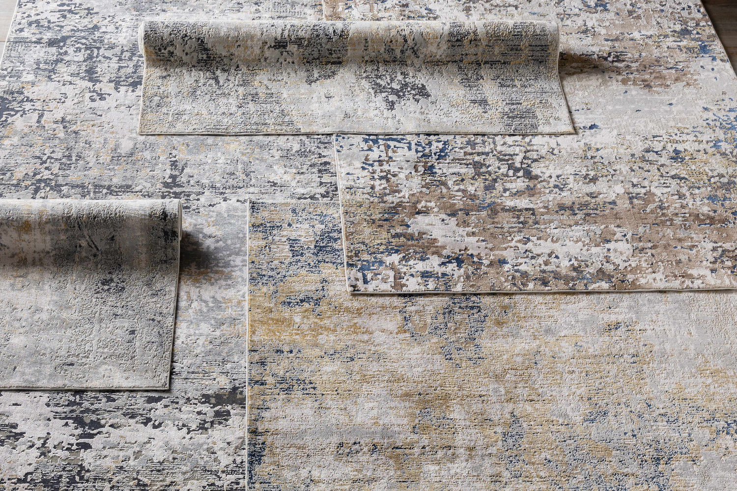 Close-up of Hayle Area Rug featuring a contemporary abstract design in charcoal, gray, mustard, and off-white hues. Styleshot