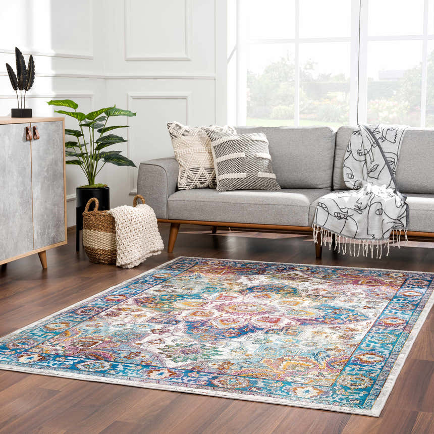 Living room scene with a colorful Mardin Area Rug, gray sofa, wood cabinet, and bright natural light. Roomscene-Rectangle