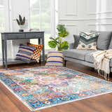 Living room scene with gray sofa and colorful Mardin Area Rug in blue, pink, mustard, and purple tones. Roomscene-Rectangle