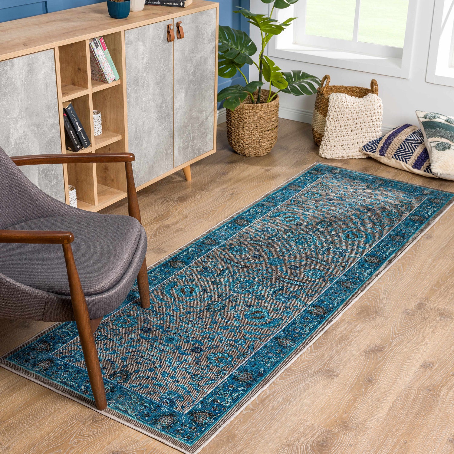 Living room scene with a Mardina Turquoise Area Rug, gray chair, and light wood cabinet. Roomscene-Runner