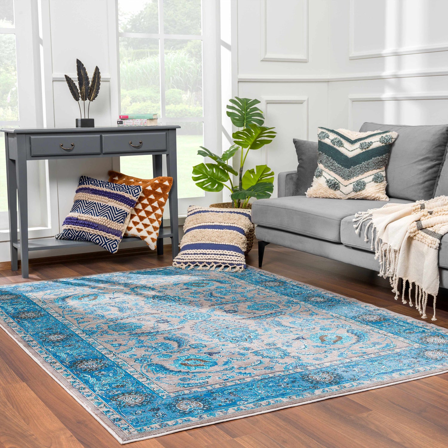 Living room scene with Mardina Turquoise Area Rug, gray sofa, console table, and decorative pillows. Roomscene-Rectangle