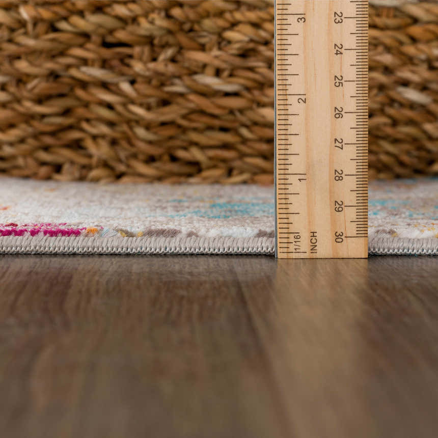 Close-up of Mardin Abstract Area Rug showing texture, pile height, and colorful pattern with pink, blue, and mustard accents. Pile