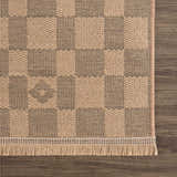 Close-up of a Nairi Checkered Washable Jute Rug. Beige and black checkered pattern with jute texture and fringe detail. Swatch
