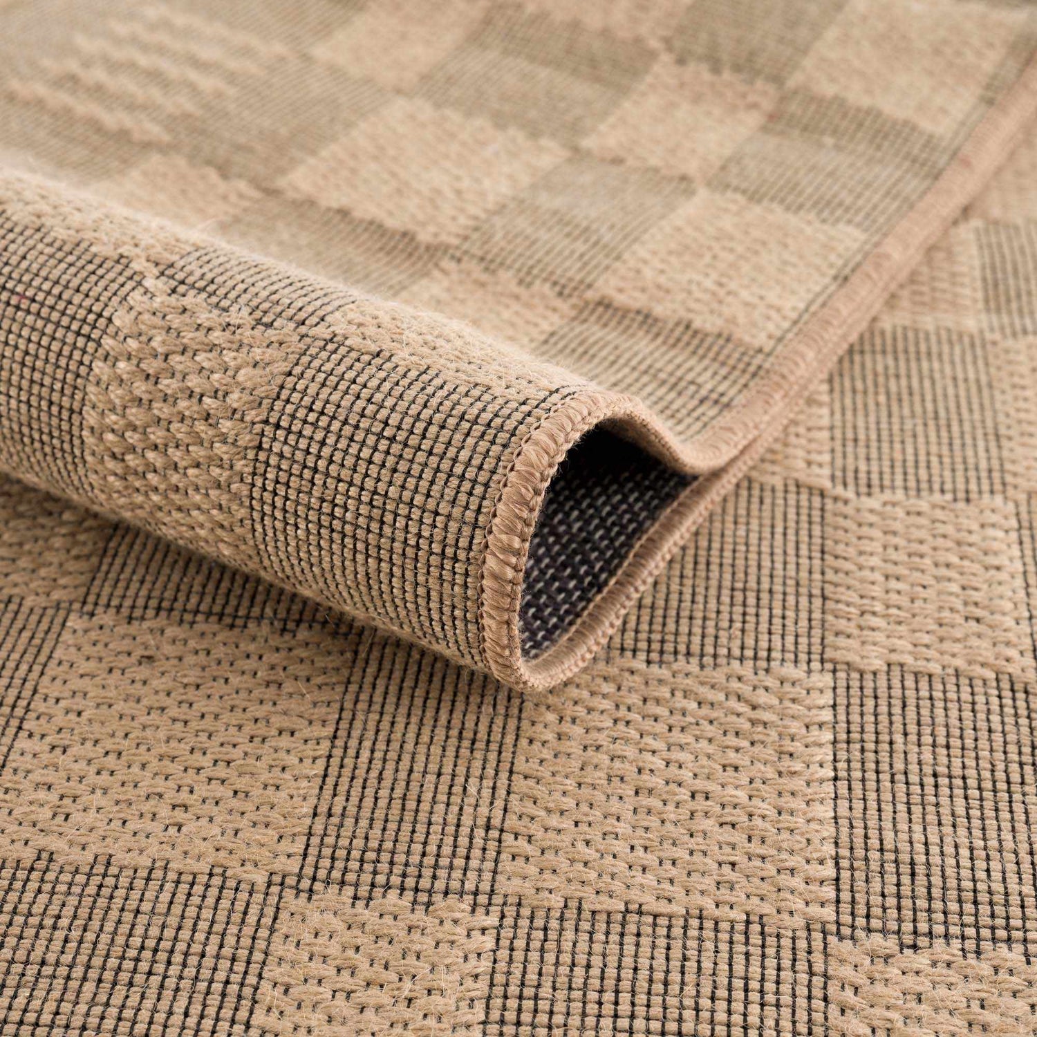 Close-up of the Nairi Checkered Washable Jute Rug showing beige and black checkered pattern and jute texture. Fold