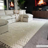 Living room scene with a bone-colored Manyas 3D Bone Area Rug with Tassels under a large white sectional sofa. Roomscene-Rectangle