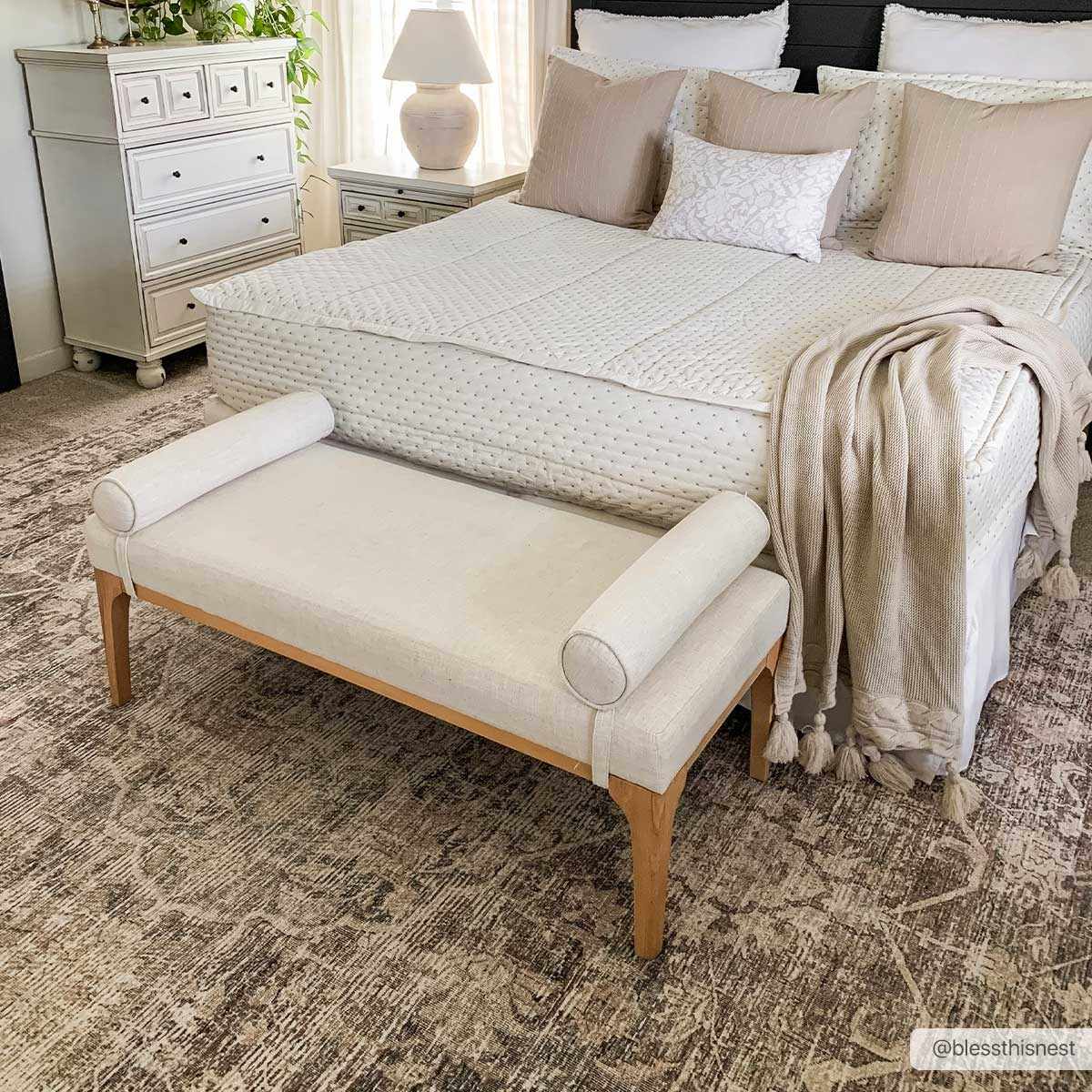 Bedroom scene with a Marlene Medallion Brown Area Rug, cream bench, white bedding, and neutral accents. Roomscene-Rectangle