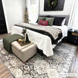 Bedroom scene with a beige and black Minoa Area Rug under a bed with Christmas decor. Roomscene-Rectangle