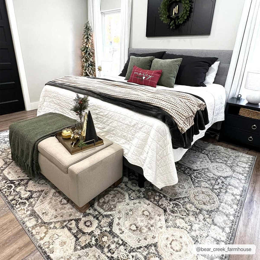 Bedroom scene with a beige and black Minoa Area Rug under a bed with Christmas decor. Roomscene-Rectangle