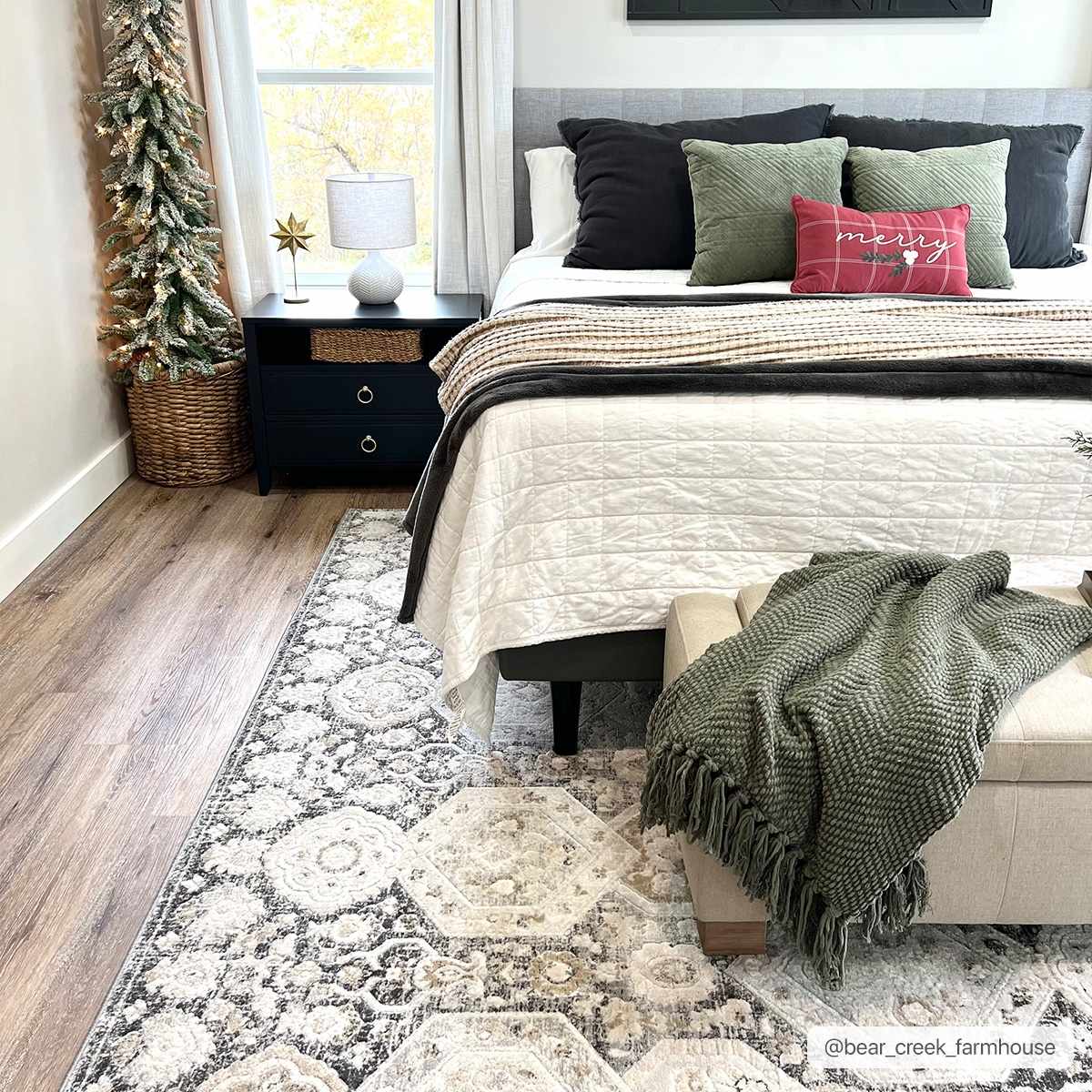 Bedroom scene with a beige and black Minoa Area Rug, Christmas tree, and neutral bedding. Roomscene-Rectangle