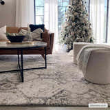 Living room with a brown leather sofa and Minoa Area Rug in beige, black, and gray. Christmas tree in background. Roomscene-Rectangle