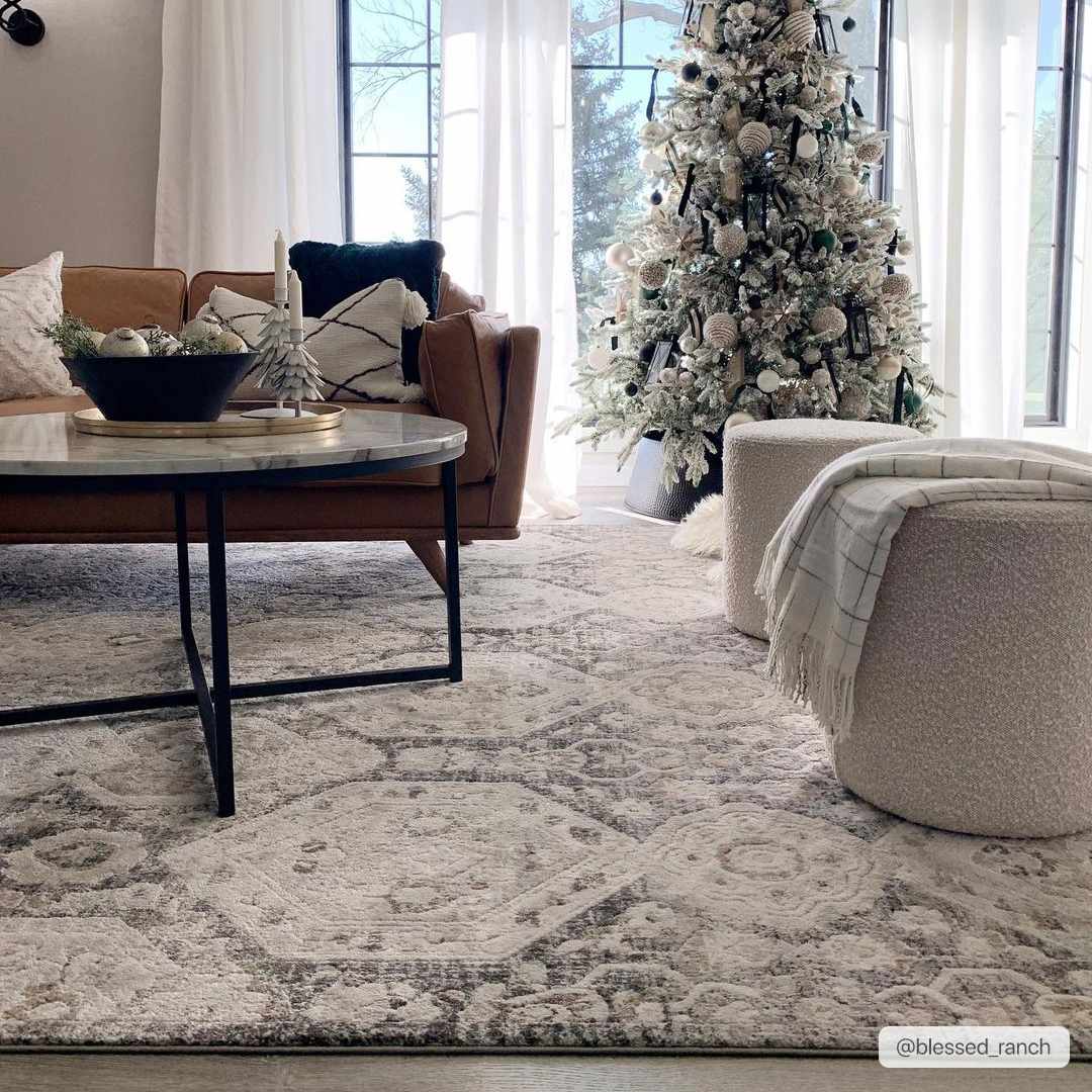 Living room with a brown leather sofa and Minoa Area Rug in beige, black, and gray. Christmas tree in background. Roomscene-Rectangle