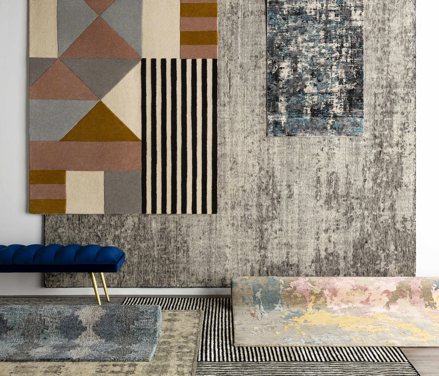 Display of various rug patterns and textures, including the Coorparoo Wool Area Rug with geometric shapes and stripes. Styleshot