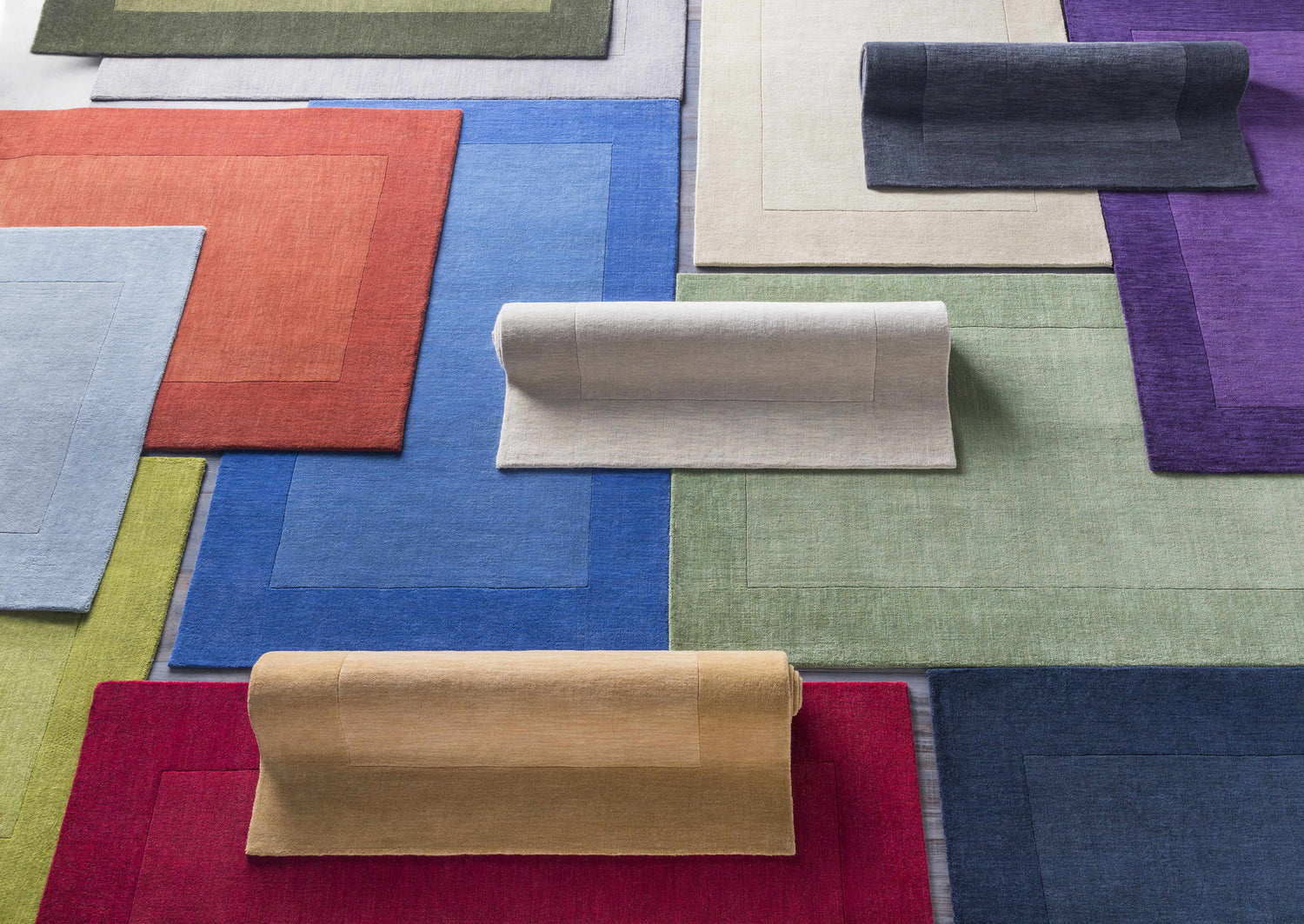 Variety of colorful hand-loomed wool rugs, including the Macedon Blue Bordered Wool Rug, in solid contemporary styles. Styleshot