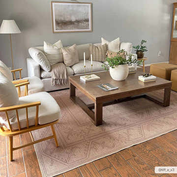 Living room scene with a light sofa and the Naja Washable Area Rug in a tan color with a geometric pattern. Roomscene-Rectangle