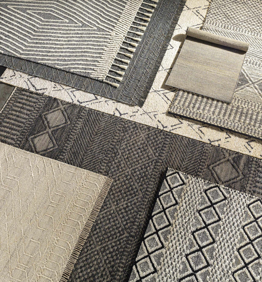Close-up of Bachauan Jute Carpet samples. Hand-woven rugs in black and cream with geometric and bohemian patterns. Styleshot