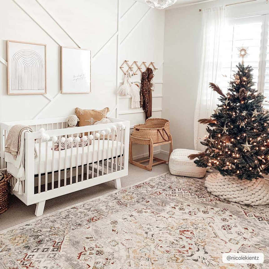 Christmas nursery with white crib and Newkirk Area Rug in brick red, charcoal, cream, and gray. Roomscene-Rectangle