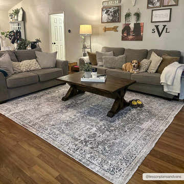 Living room scene with a gray couch and the Olive Holi-2304 Washable Area Rug, showcasing its vintage design. Roomscene-Rectangle