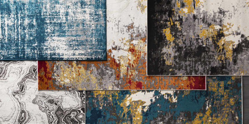 Close-up of multiple Nuevo Black Marble Carpet samples in black, cream, gray, and teal with abstract patterns. Styleshot