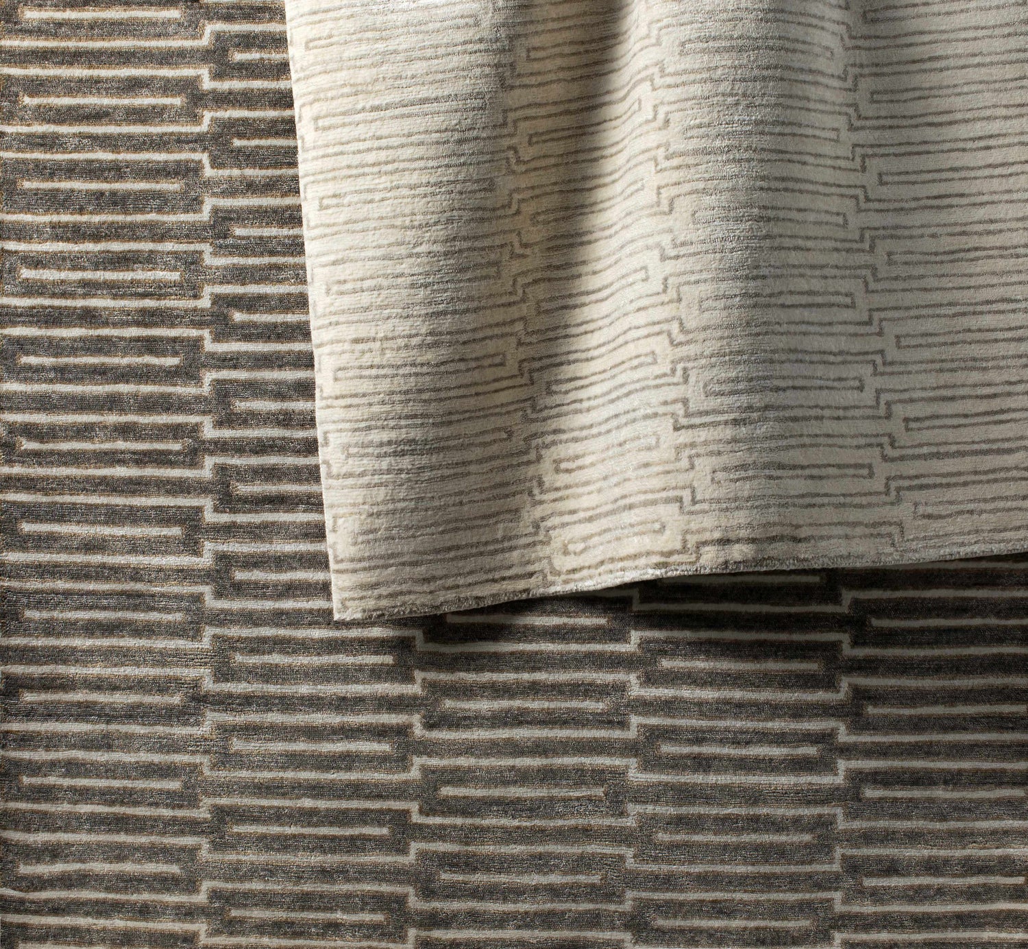 Close-up of the hand-knotted Partlow Area Rug. Beige and cream viscose rug with a contemporary geometric pattern. Styleshot