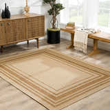 Living room scene with a camel Isoko Bordered Faux Jute Rug, wood cabinet, bench, and plant creating a warm, inviting space. Roomscene-Rectangle