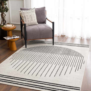 Living room scene with gray chair and Angus Black&White Geometric Area Rug with a modern, minimalist design. Roomscene-Rectangle