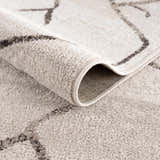 Close-up of the Azzan Cream & Charcoal Area Rug showing the plush texture and Southwestern-inspired geometric design. Fold