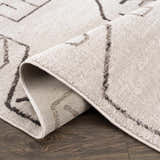 Close-up of the Azzan Cream & Charcoal Area Rug showing its geometric Southwestern design and soft, textured pile. Fold