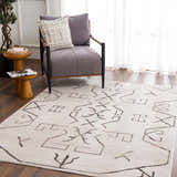 Living room scene with Azzan Cream & Charcoal Area Rug, gray chair, wood side tables, and hardwood floors. Southwestern style. Roomscene-Rectangle