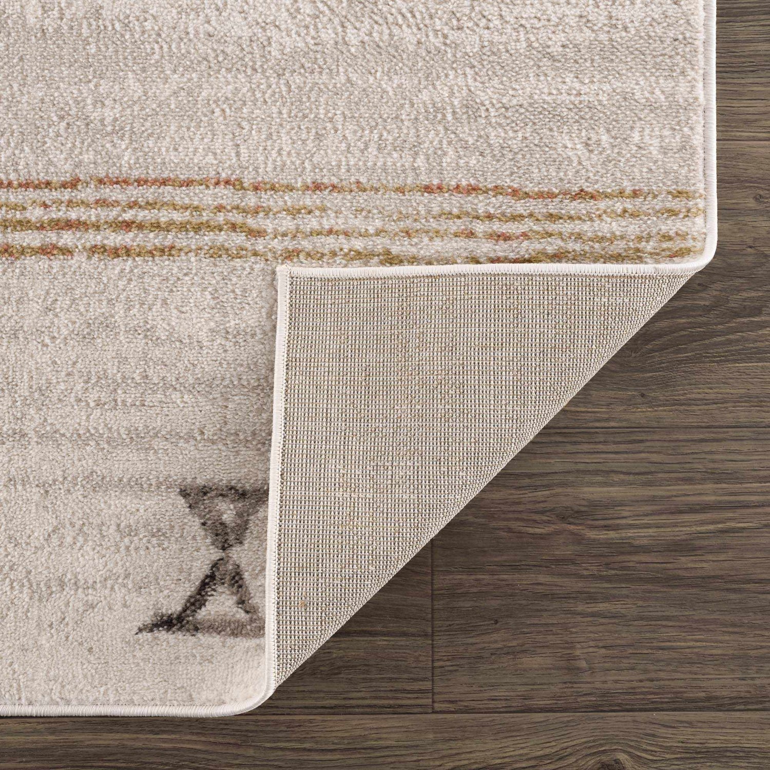 Close-up of the Deja Cream & Gold Area Rug showing the cream color, gold accents, soft texture, and rug backing. Fold