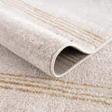 Close-up of the Deja Cream & Gold Area Rug showing its plush texture and subtle cream, gold, and trellis stripe design. Fold