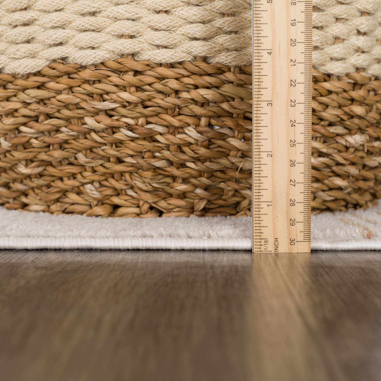 Close-up of the Deja Cream & Gold Area Rug showing texture and pile height with a ruler for scale. Pile
