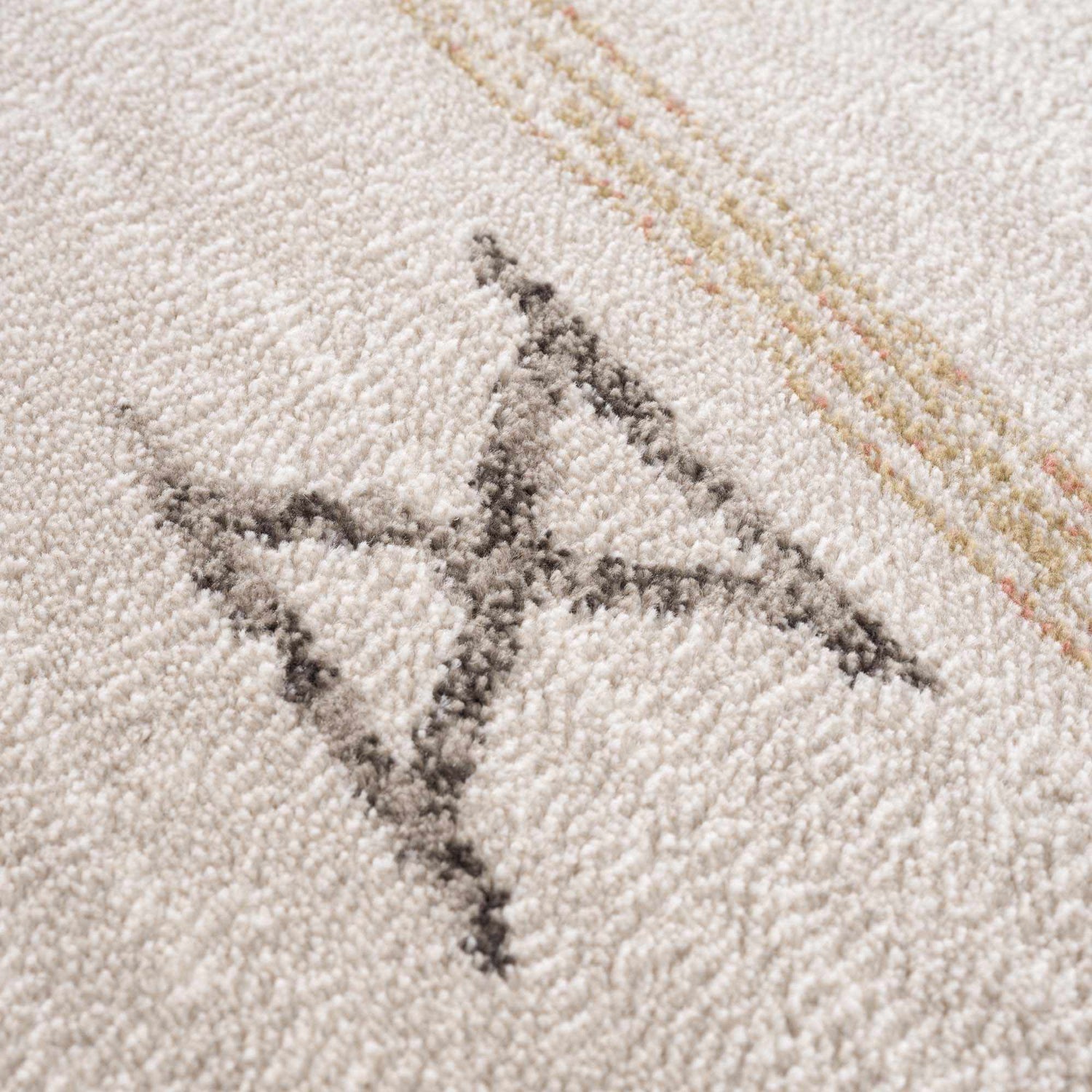 Close up of Deja Cream & Gold Area Rug showing the cream texture and geometric gold and gray pattern. Texture