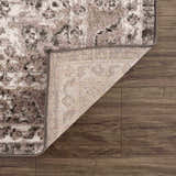 Close-up of the Albie Charcoal & Beige Area Rug showing its traditional pattern, woven texture, and backing on dark wood floor. Fold