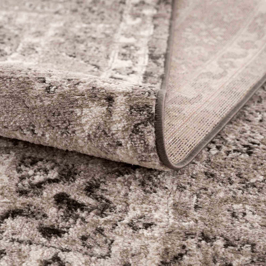 Close up of the Albie Charcoal & Beige Area Rug showing its plush texture, neutral colors, and woven backing. Fold