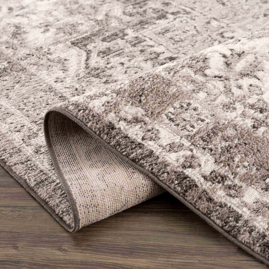 Close-up of the Albie Charcoal & Beige Area Rug showing its traditional pattern, soft texture, and durable machine-woven construction. Fold
