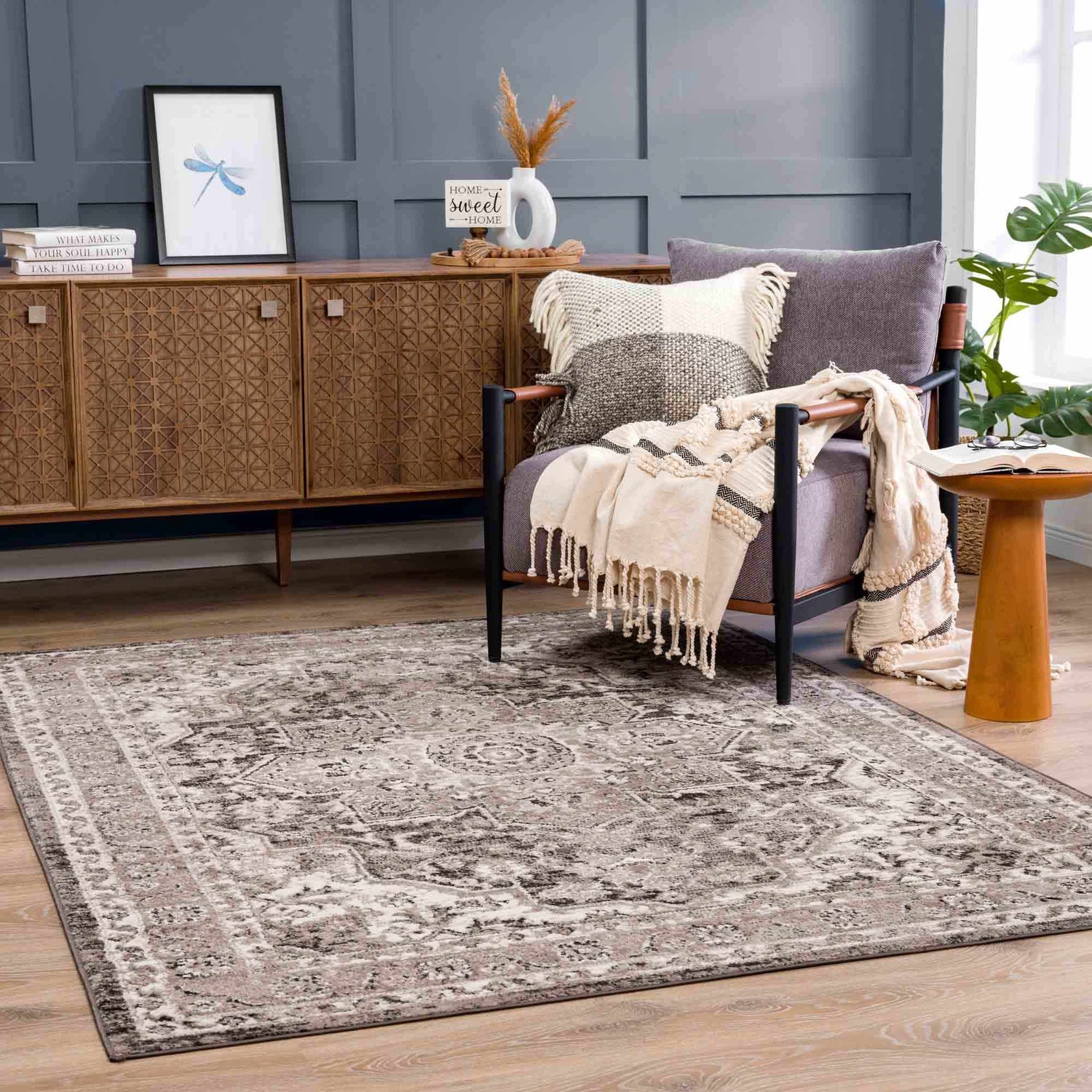 Living room scene with Albie Charcoal & Beige Area Rug, wood cabinet, gray chair, and neutral decor. Farmhouse style. Roomscene-Rectangle