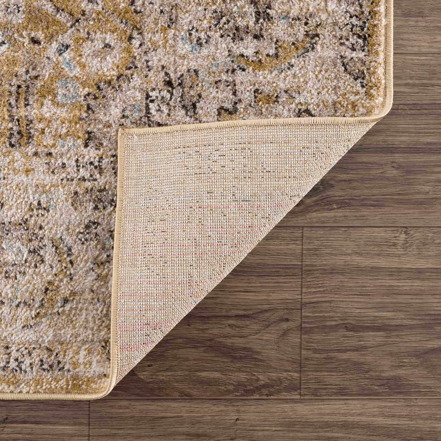 Close-up of the Anana Gold & Beige Area Rug showing its traditional pattern, soft texture, and durable machine-woven construction. Fold
