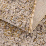 Close-up of the Anana Gold & Beige Area Rug showing its traditional pattern, soft texture, and woven backing. Fold