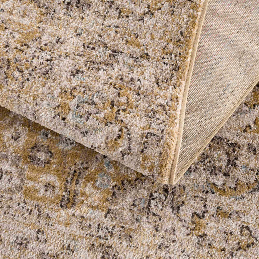 Close-up of the Anana Gold & Beige Area Rug showing its traditional pattern, soft texture, and woven backing. Fold