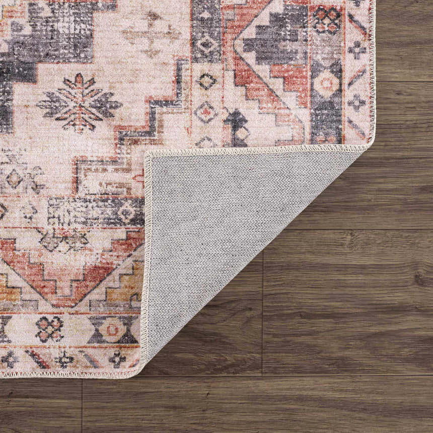 Close-up of the Isugod Washable Area Rug showing its beige, black, and brick red traditional Southwestern pattern and non-slip backing. Fold