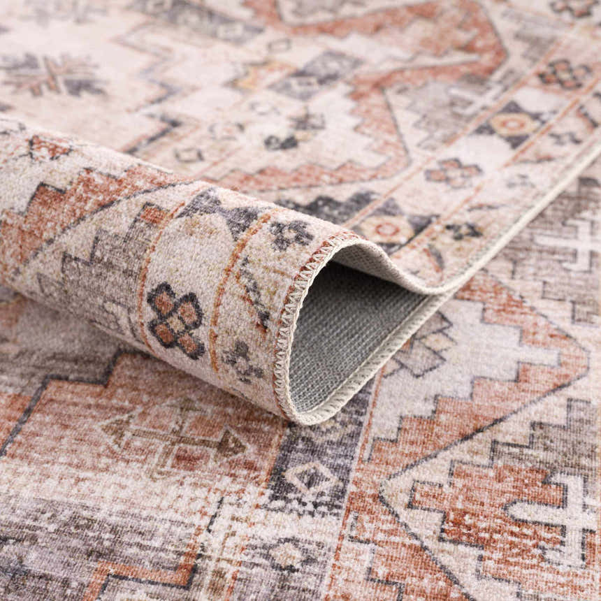 Close-up of the Isugod Washable Area Rug showing the traditional beige, brick red, and gray oriental pattern. Fold