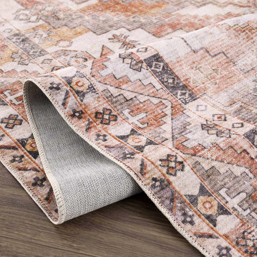 Close-up of the Isugod Washable Area Rug showing its beige, brown, and brick red traditional Southwestern pattern and texture. Fold