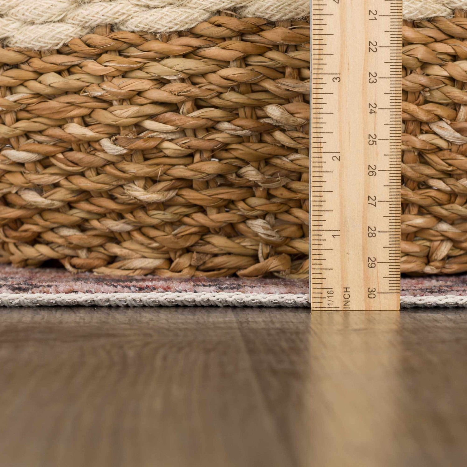 Close-up of Isugod Washable Area Rug showing rug thickness next to a ruler. Beige, brick red, and ivory colors visible. Pile