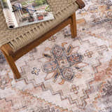 Close-up of the beige Isugod Washable Area Rug with a traditional, Southwestern-inspired design and brick red, brown, and black accents. Styleshot