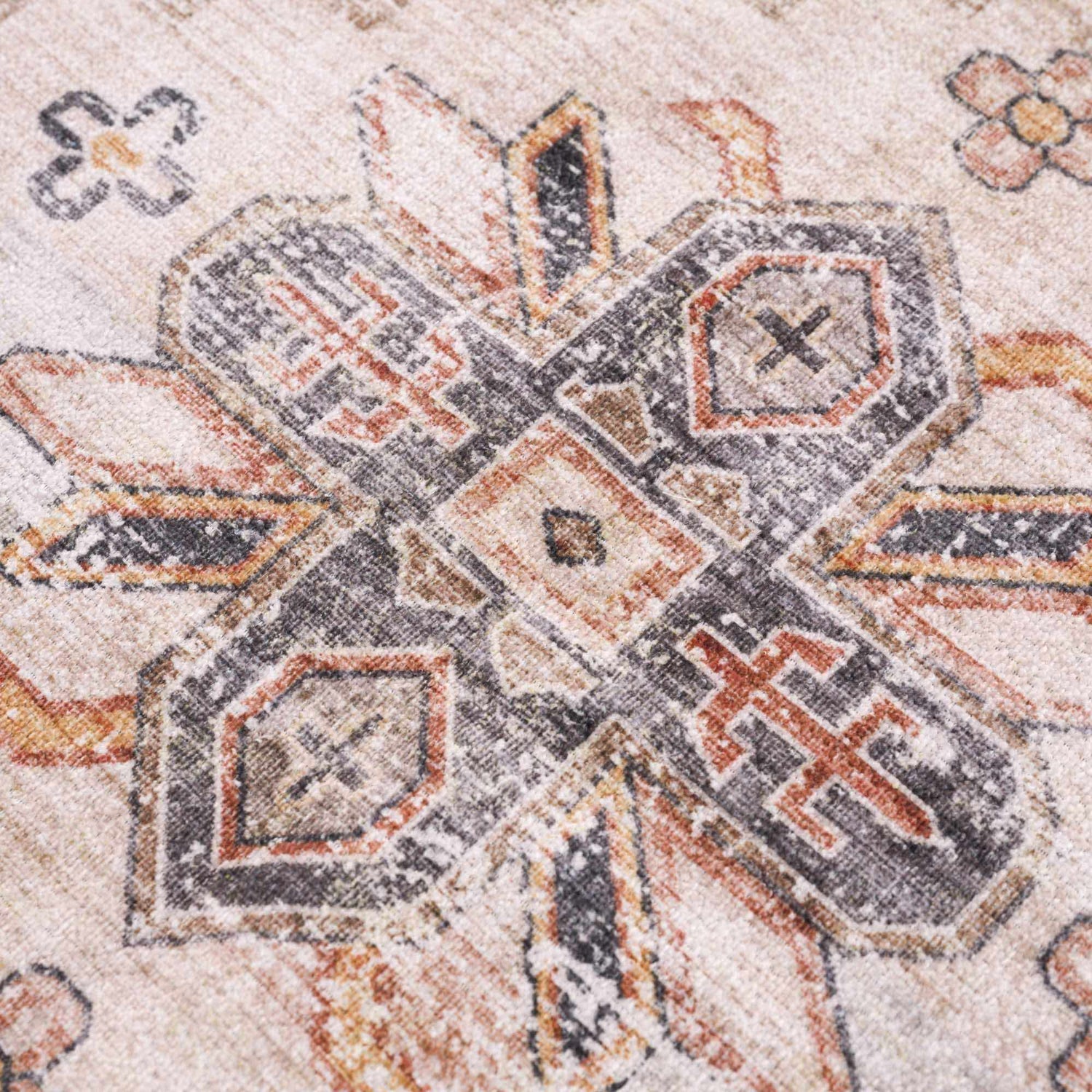 Close-up of the Isugod Washable Area Rug showing beige, black, and brick red traditional pattern. Texture